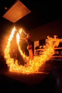 Fire performer at an Ayia Napa club showcasing a fiery spectacle during a vibrant night party.